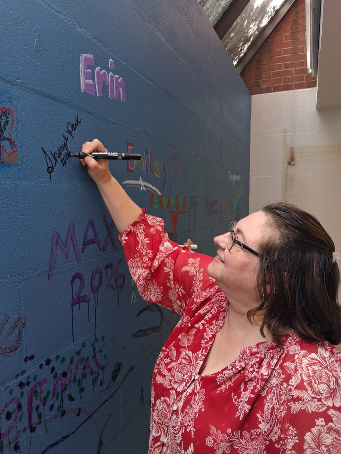Sheryl Park signing the community wall at the Spring Fling